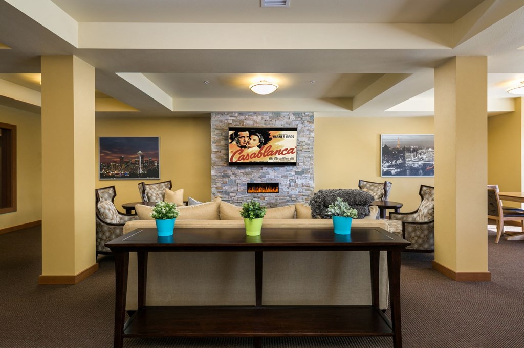 a living room with a couch and a table in front of a fireplace
