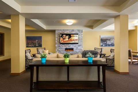a living room with a couch and a table in front of a fireplace