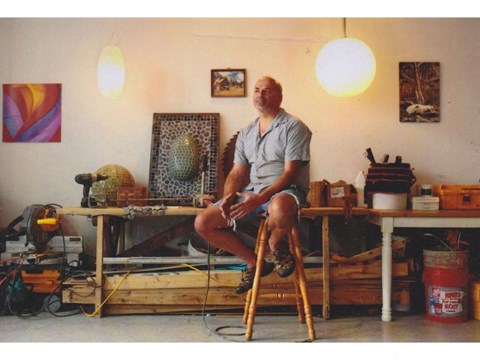 a man sitting on a stool in front of a table