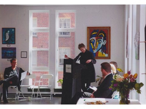 a woman standing at a podium in front of a group of people