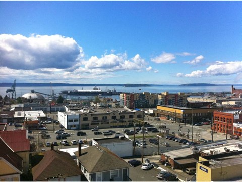 A cityscape with buildings, cars, and a body of water.