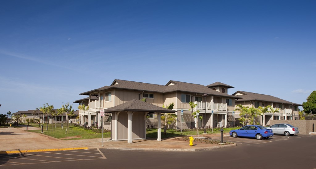 a large apartment building with cars parked in a parking lot