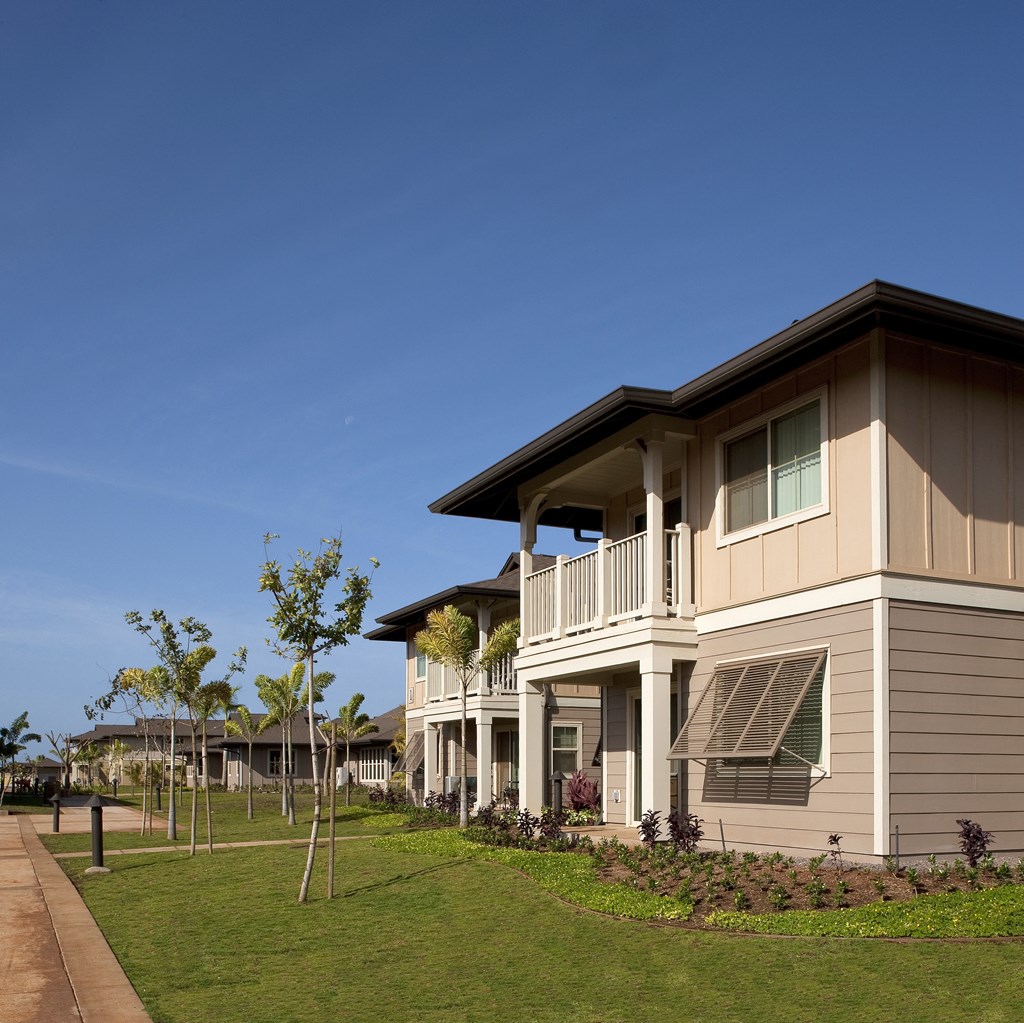 a row of houses on the side of a green lawn