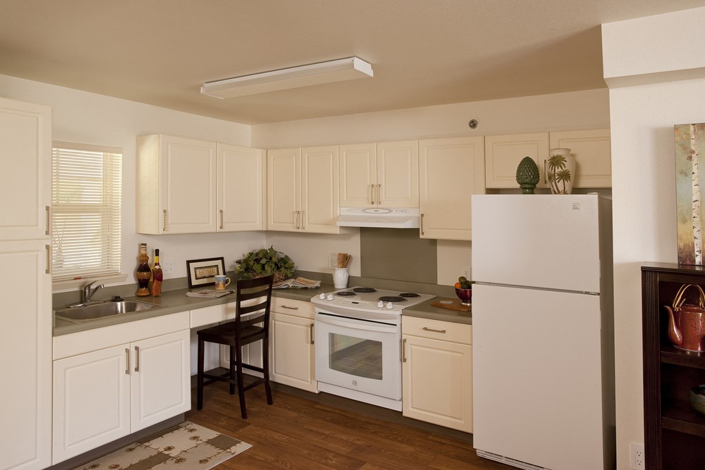 a kitchen with white cabinets and appliances and a counter top