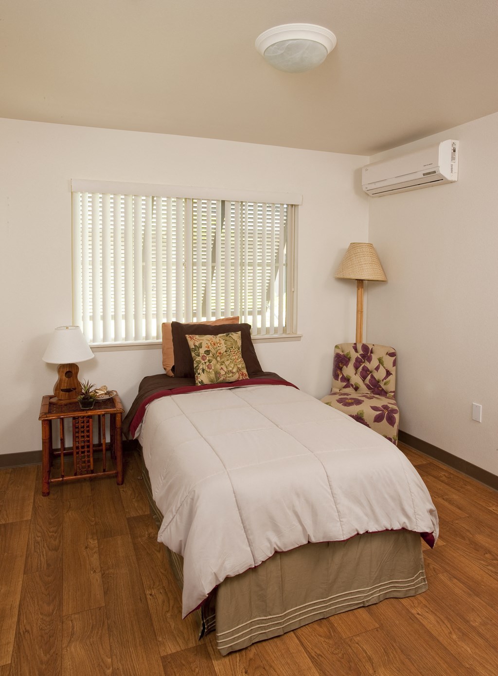 a bedroom with a bed and a chair and a window