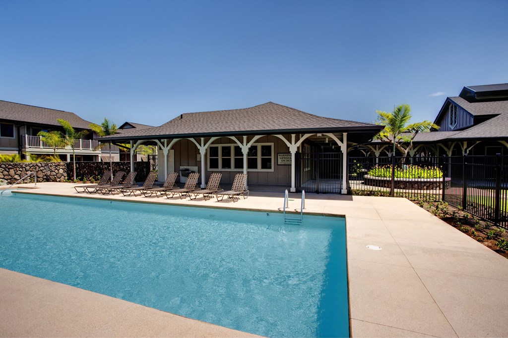 a swimming pool in front of a house with a pavilion