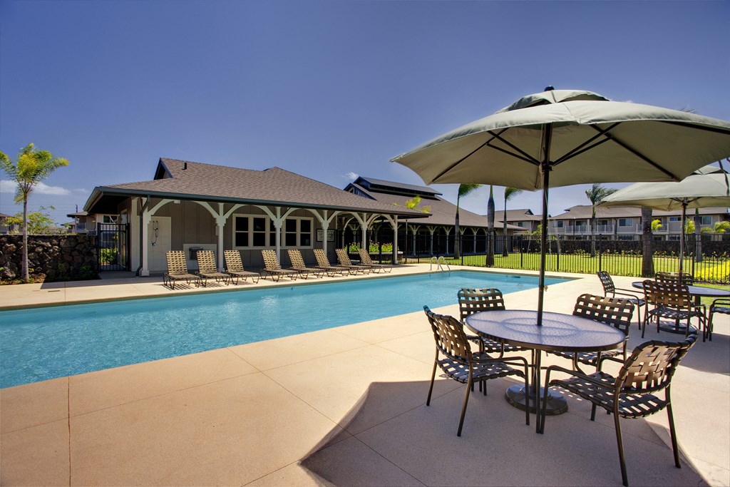 a swimming pool with tables and chairs and umbrellas