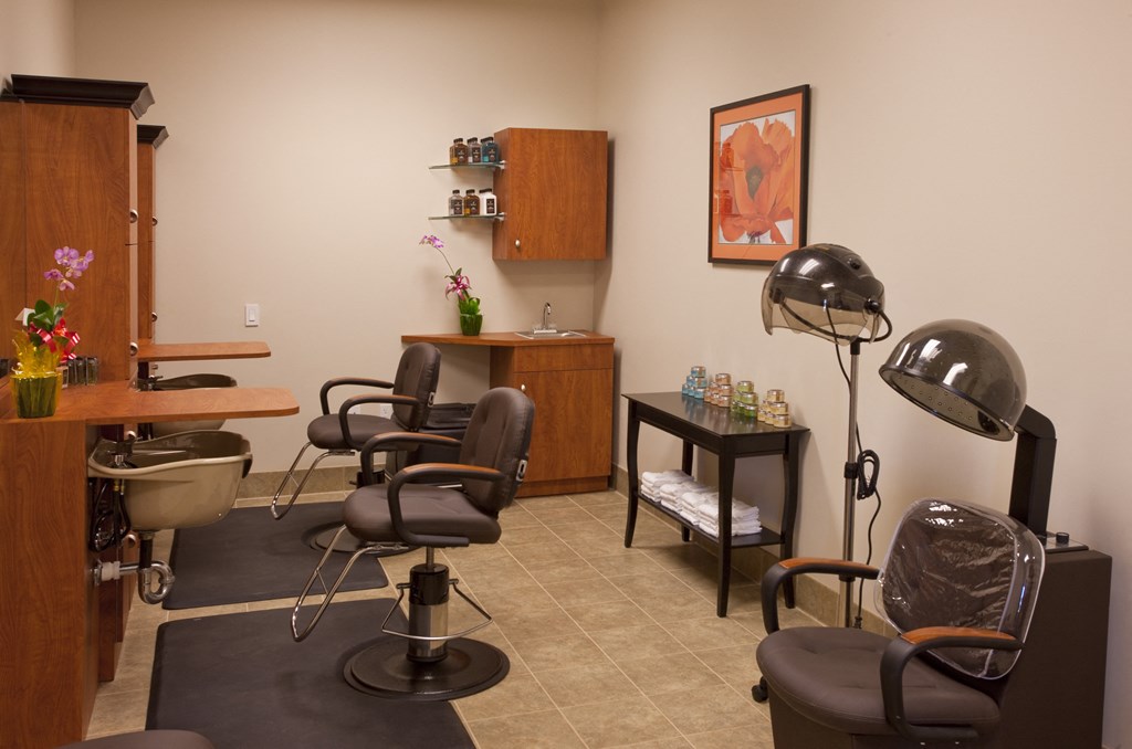 a salon room with chairs and a table and a lamp