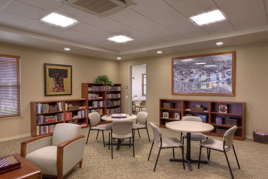 a library with tables and chairs and shelves of books