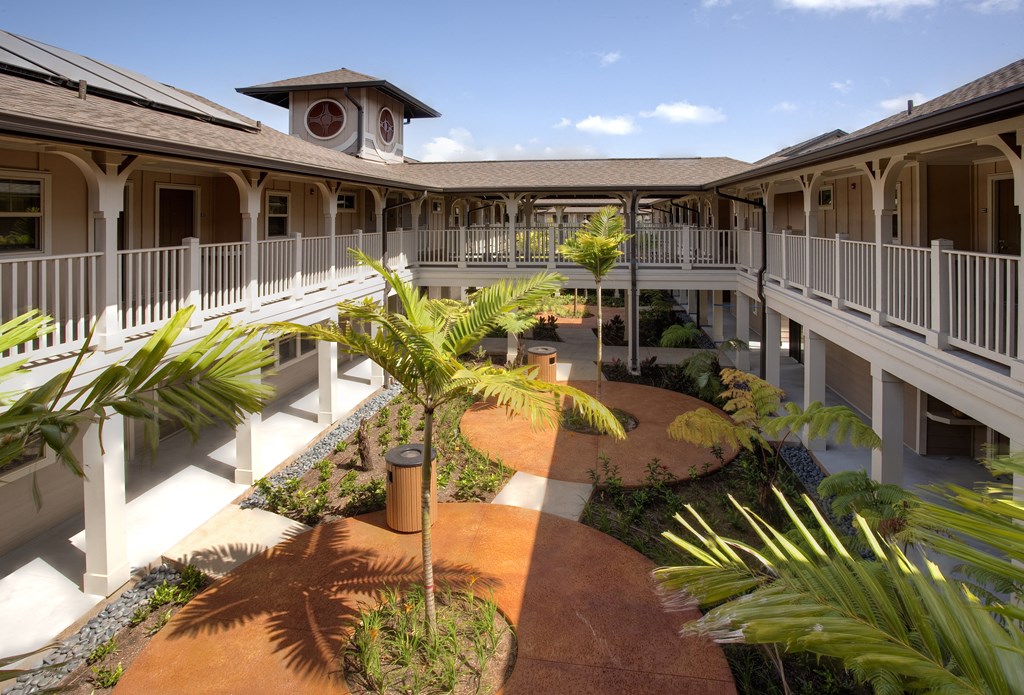 a courtyard with palm trees and a clock tower