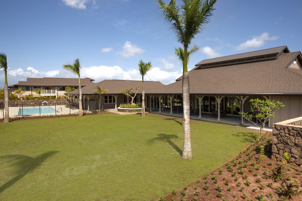 a yard with palm trees in front of a building