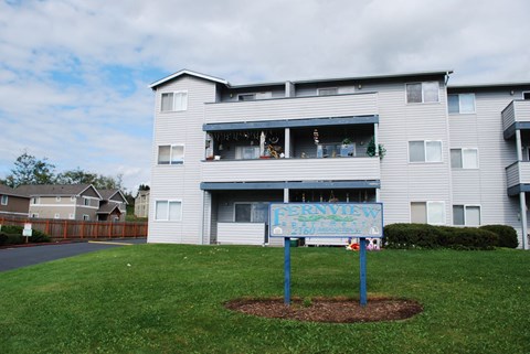 an apartment building with a sign in front of it