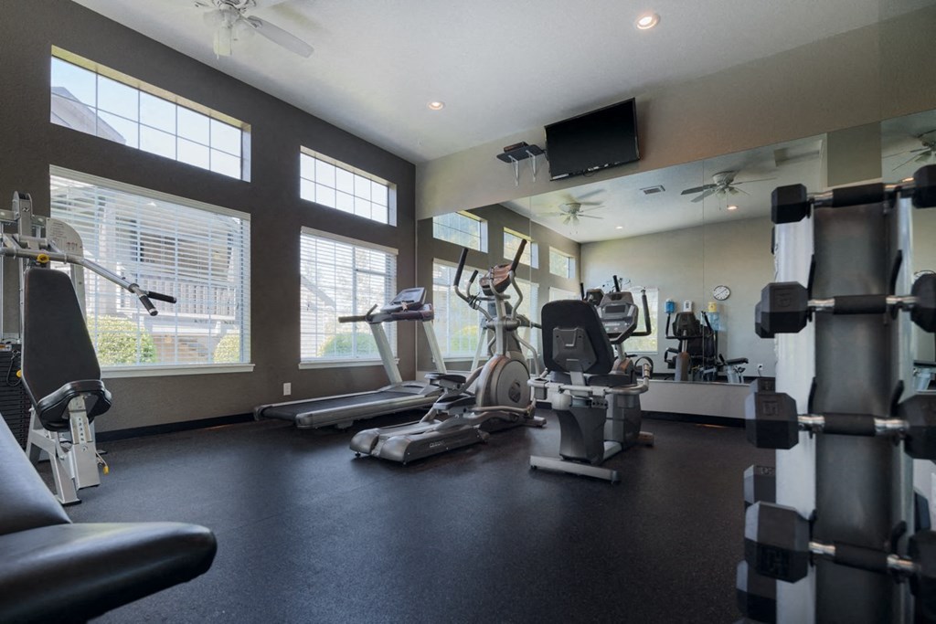 a gym with weights and cardio equipment at the at the grove apartments