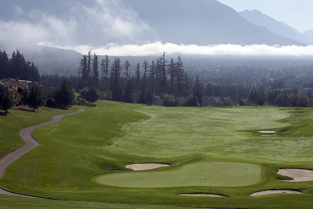 a golf course with mountains in the background