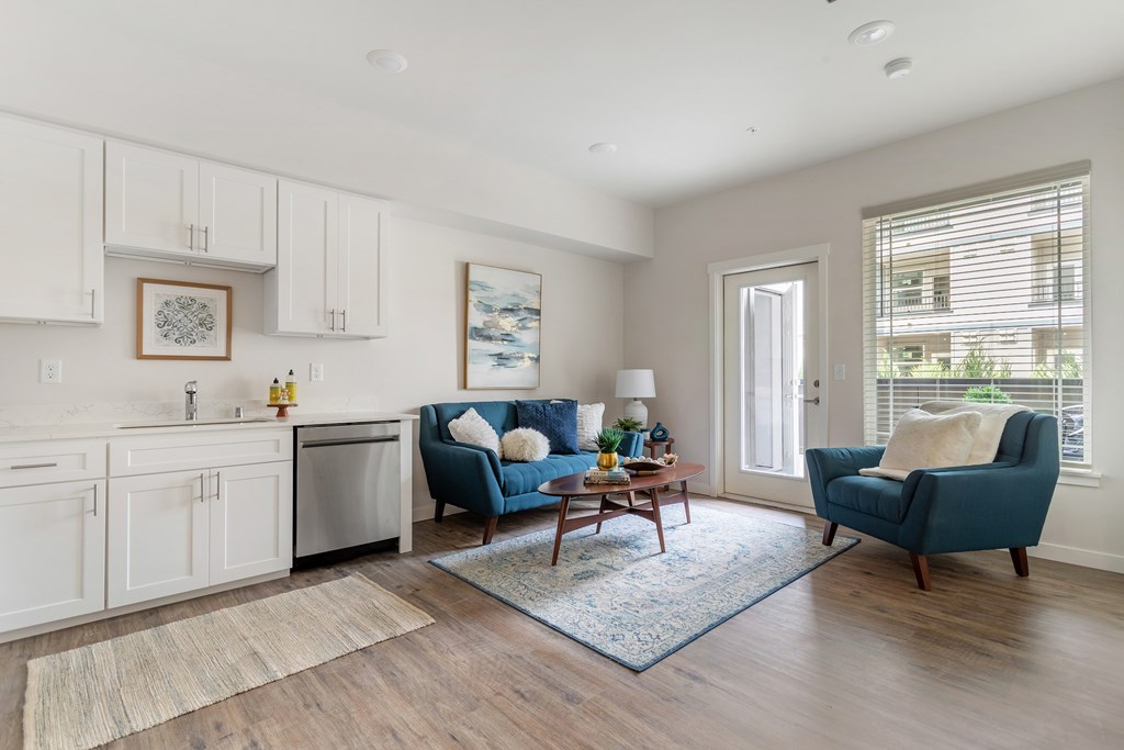 A living room with a blue chair and a white wall.