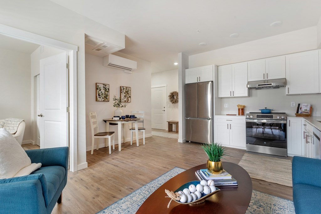 A modern kitchen with a dining table and chairs in the middle of the room.