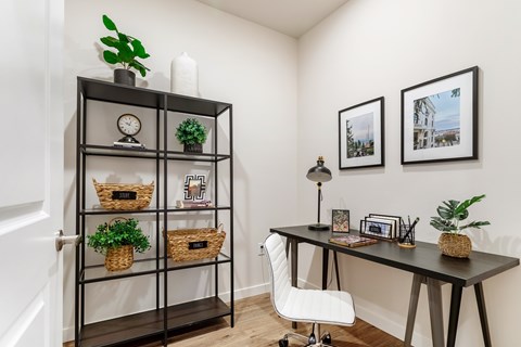 A black shelf with a variety of items including a clock, a plant, and a basket with a sign that reads "F".