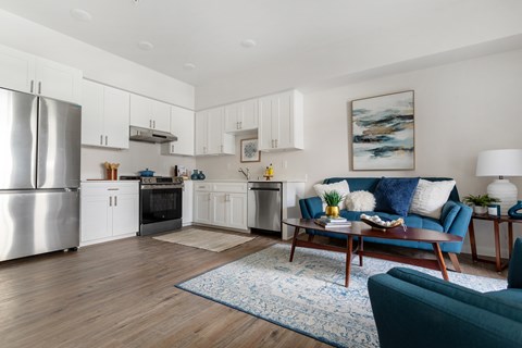 A modern kitchen with a blue couch and a rug.