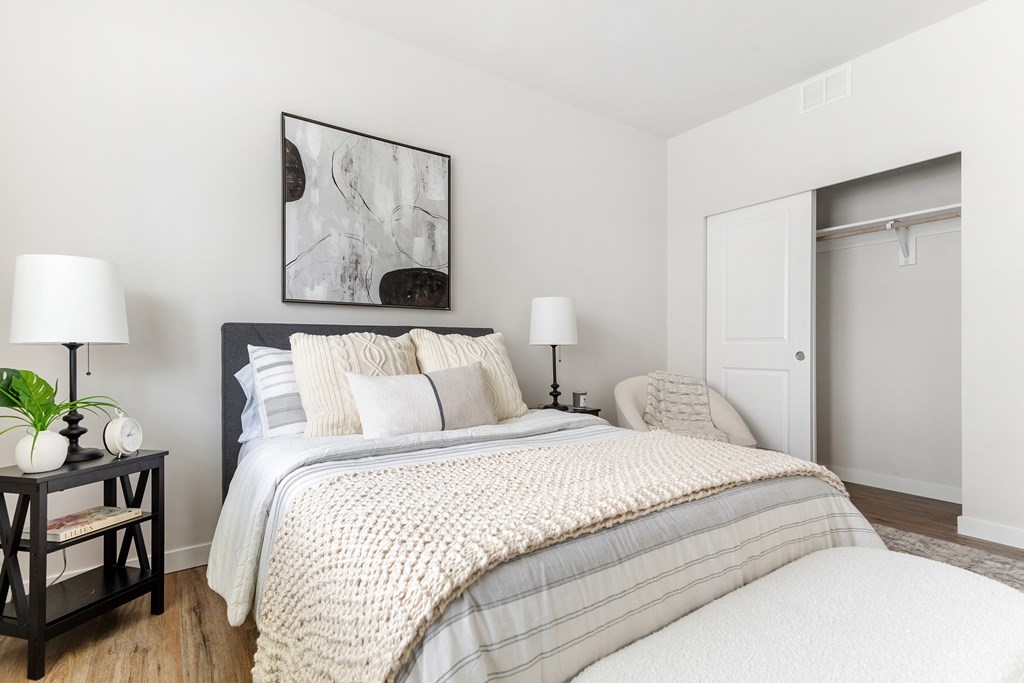 A bedroom with a bed, nightstand, and lamp.
