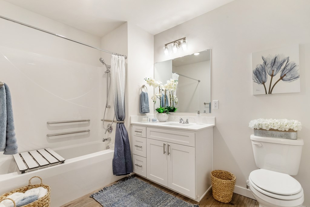 A white bathroom with a white toilet, white sink, and a white bathtub.