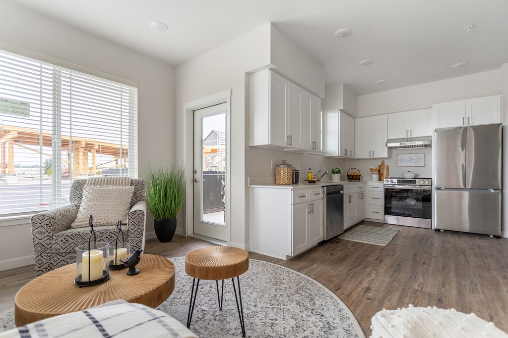 A modern kitchen with white cabinets and stainless steel appliances.