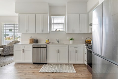 A kitchen with white cabinets and a large island.