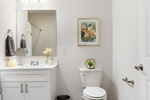 A white toilet sits next to a white sink in a bathroom.