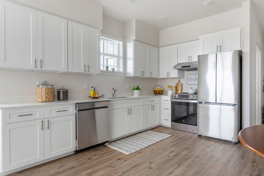 A modern kitchen with white cabinets and stainless steel appliances.