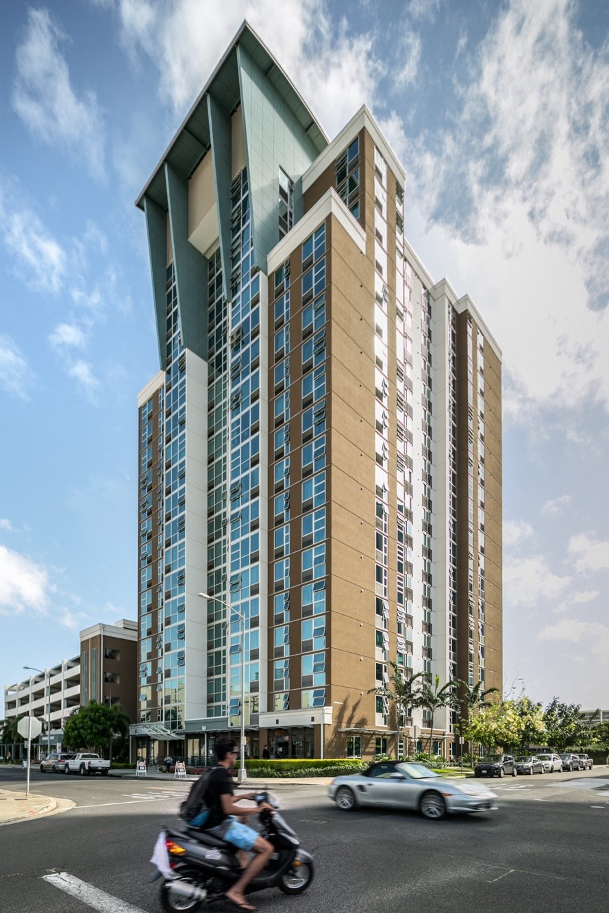 a man riding a motorcycle in front of a tall building