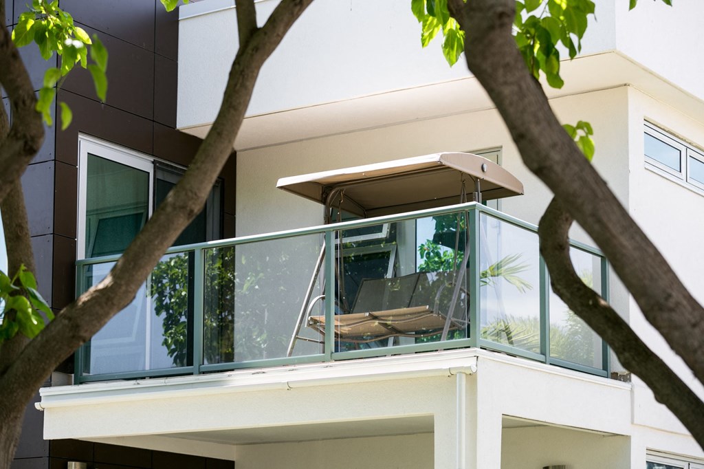 a balcony with a chair and a table on a balcony of a house