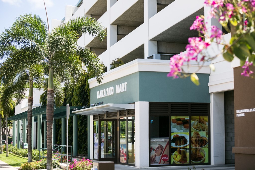 a building with palm trees and flowers in front of it