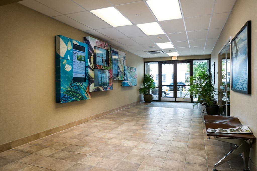 a hallway with paintings on the wall in a hospital lobby