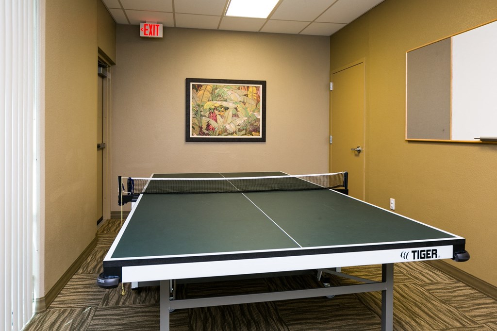a room with a ping pong table and a painting on the wall