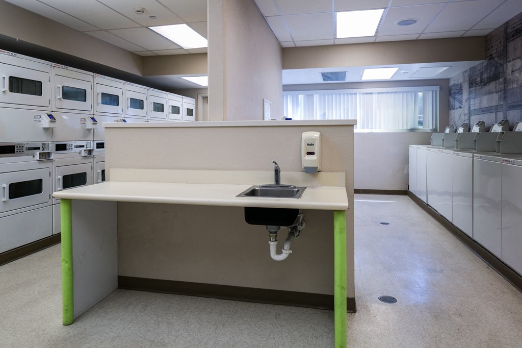 a sink in the middle of a kitchen in an empty room