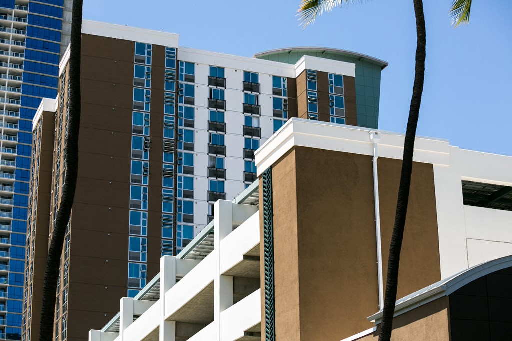 a view of the side of a hotel with palm trees