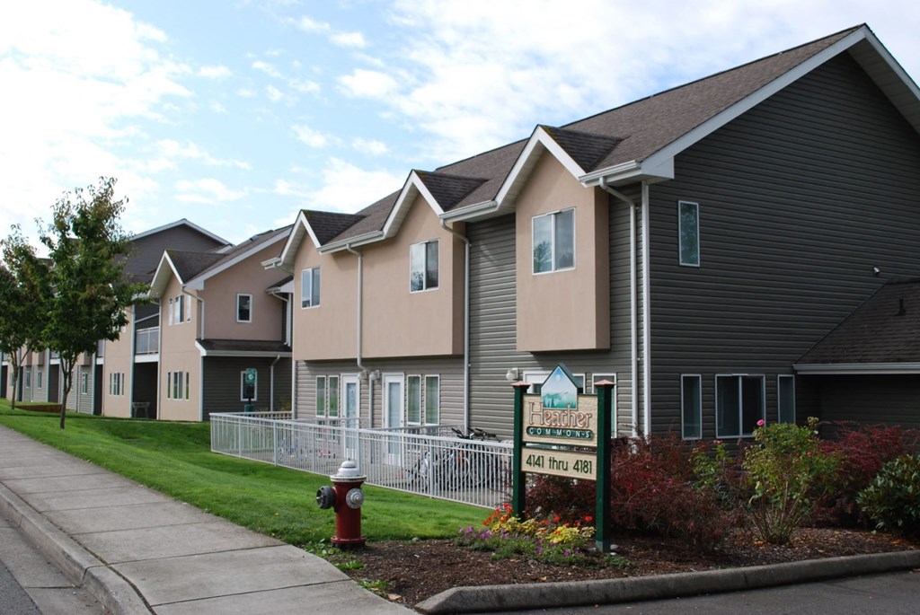 a row of townhouses with a sign in front of a sidewalk
