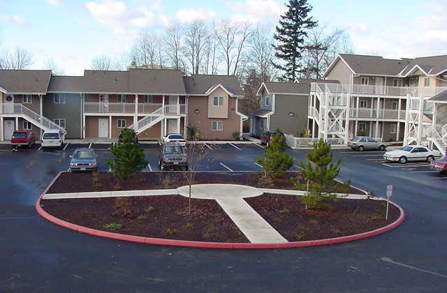 an empty parking lot in front of an apartment building