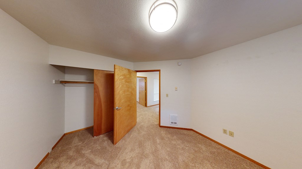 a bedroom with a closet and a door to a bathroom