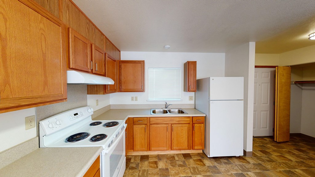 a kitchen with white appliances and wooden cabinets