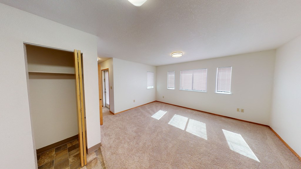 an empty living room with a door to a closet