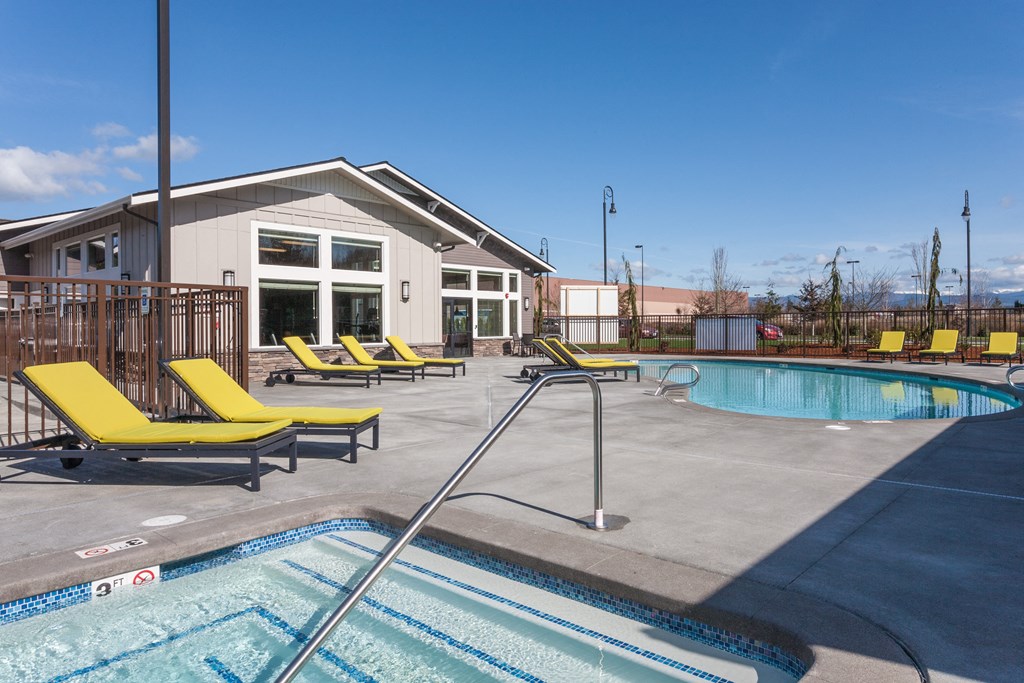 our apartments have a swimming pool and a clubhouse with yellow lounge chairs
