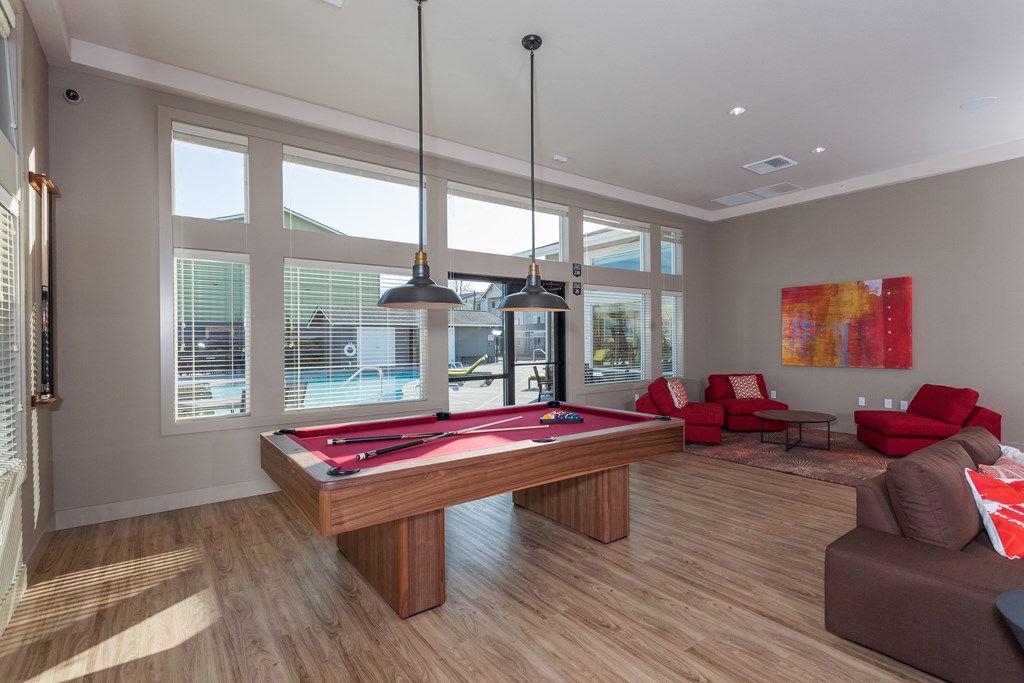 a game room with a pool table and couches