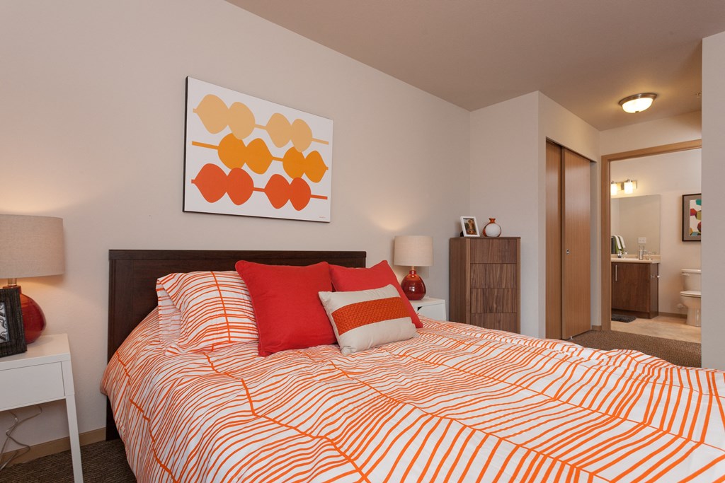 a bedroom with a bed and a painting on the wall