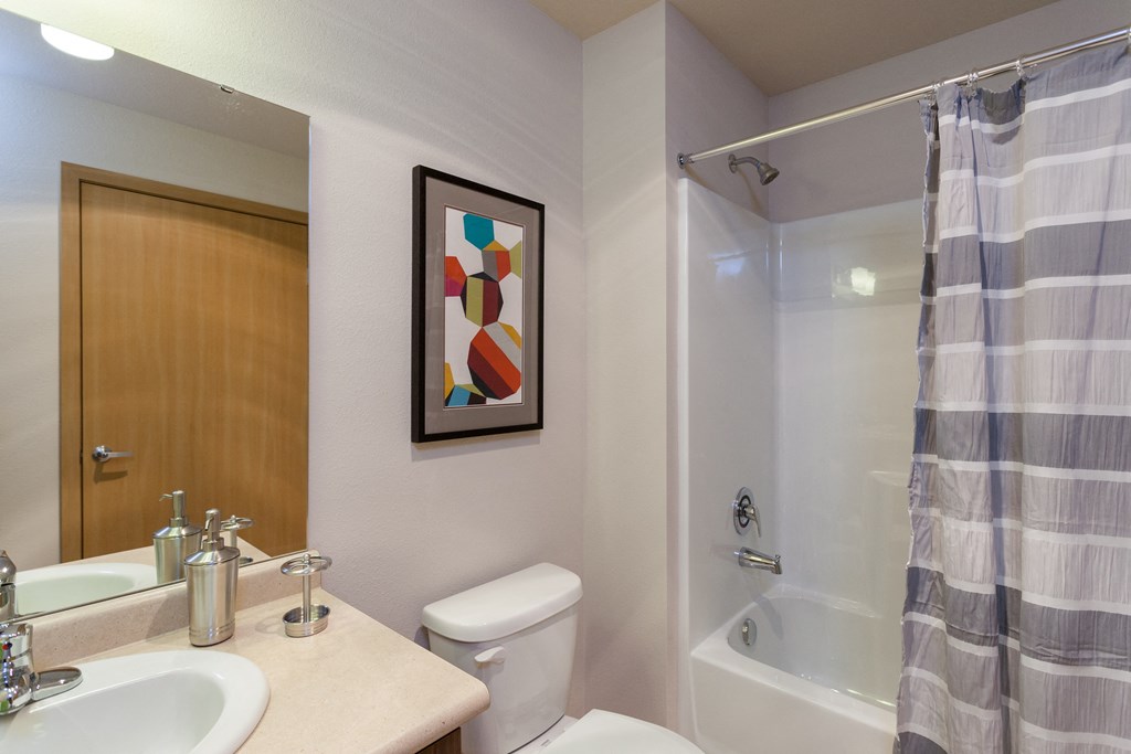 a bathroom with a shower and a sink and a toilet