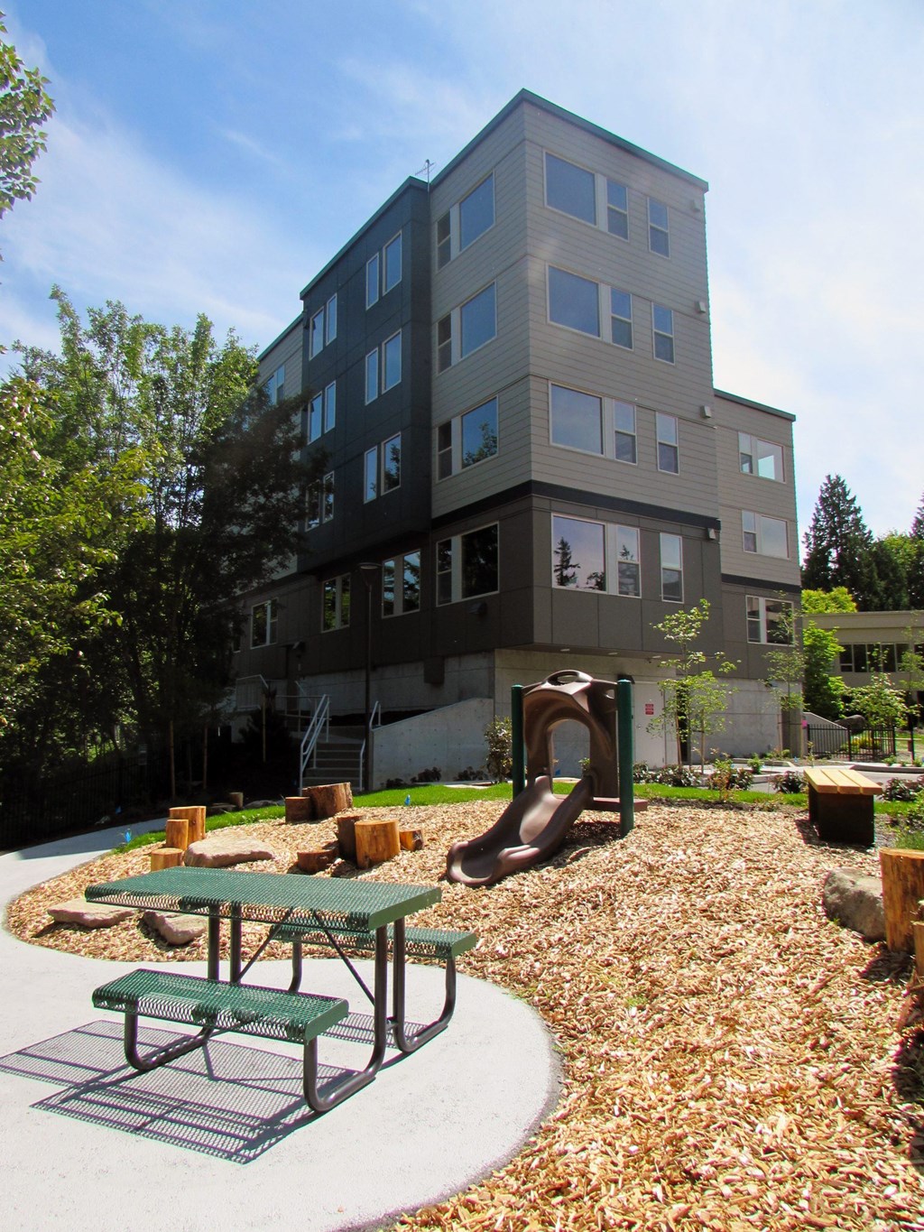 A playground area in front of a multi-story building.