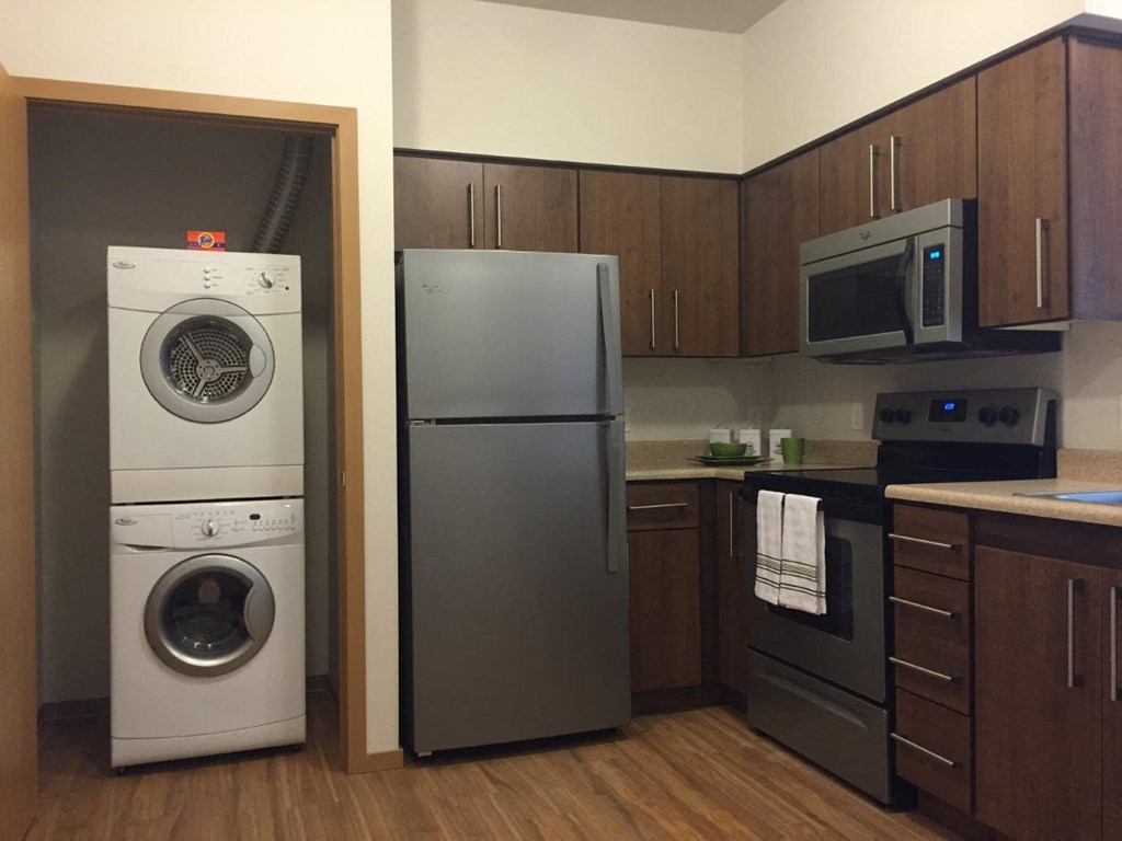 a kitchen with a washing machine and a refrigerator