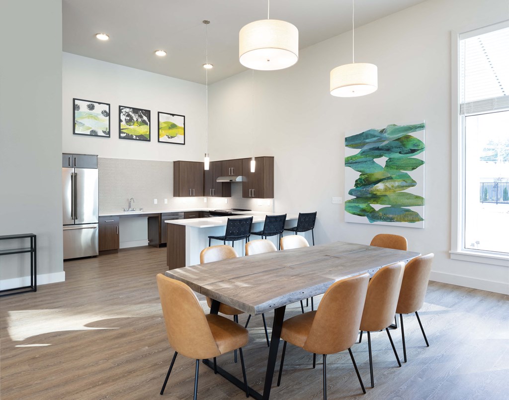 a dining room and kitchen with a wooden table and chairs