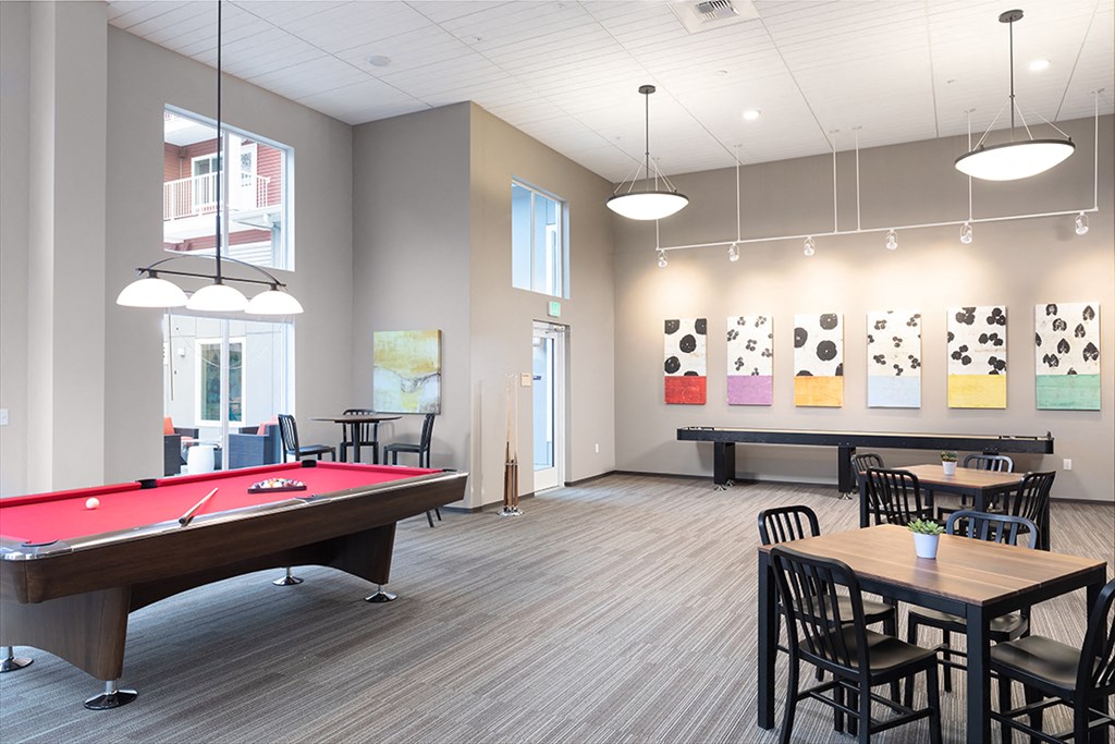 a community room with a pool table and tables