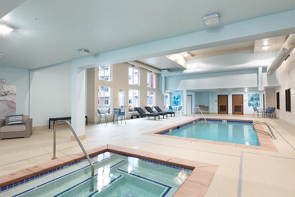 a large indoor swimming pool with a jacuzzi and a poolside spa