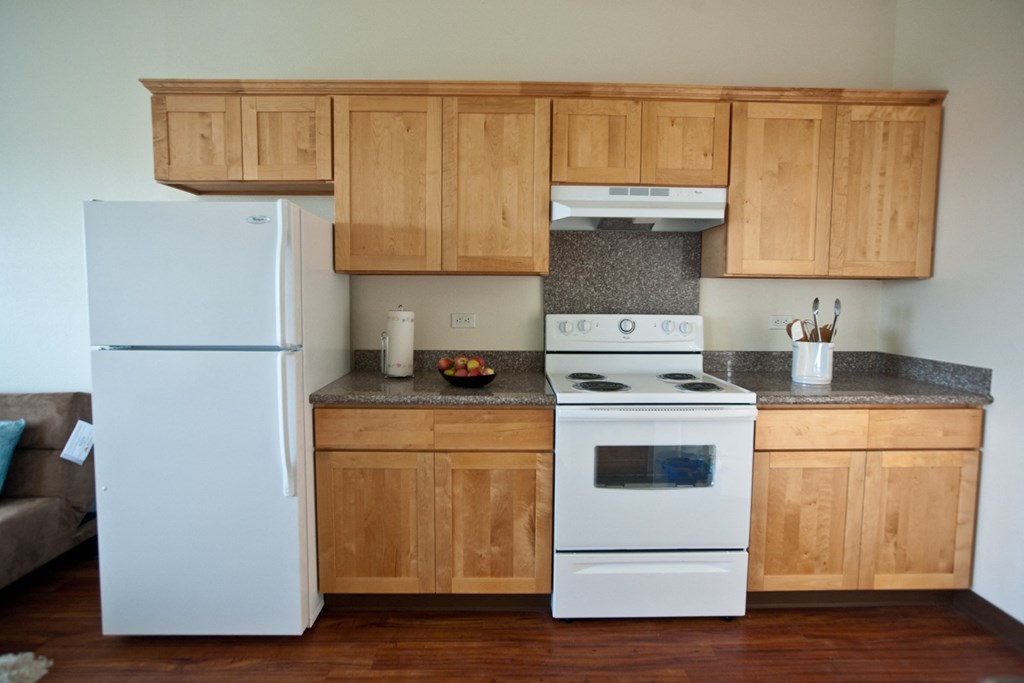 a kitchen with white appliances and wooden cabinets